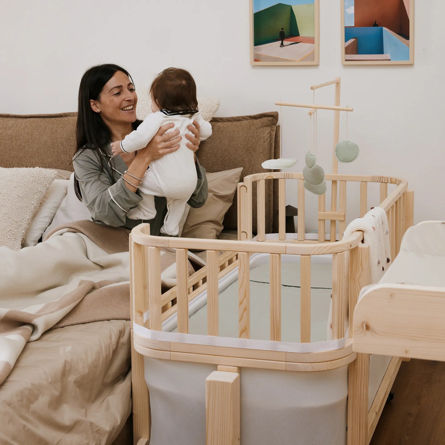 mamma che prende in braccio la propria bambina dalla culla next to me