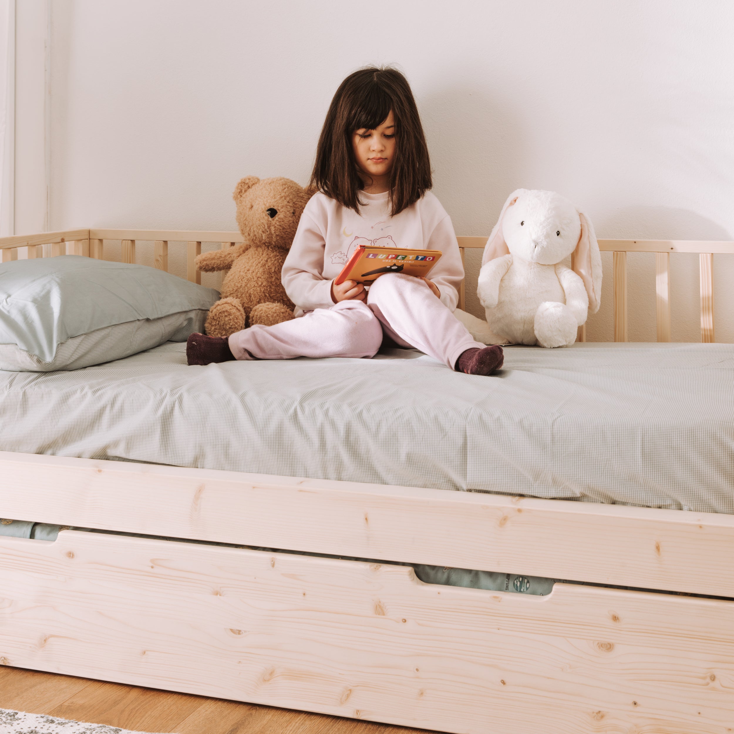 bambina legge sul suo letto zero+ earth con barriere modulari e cassettone estraibile