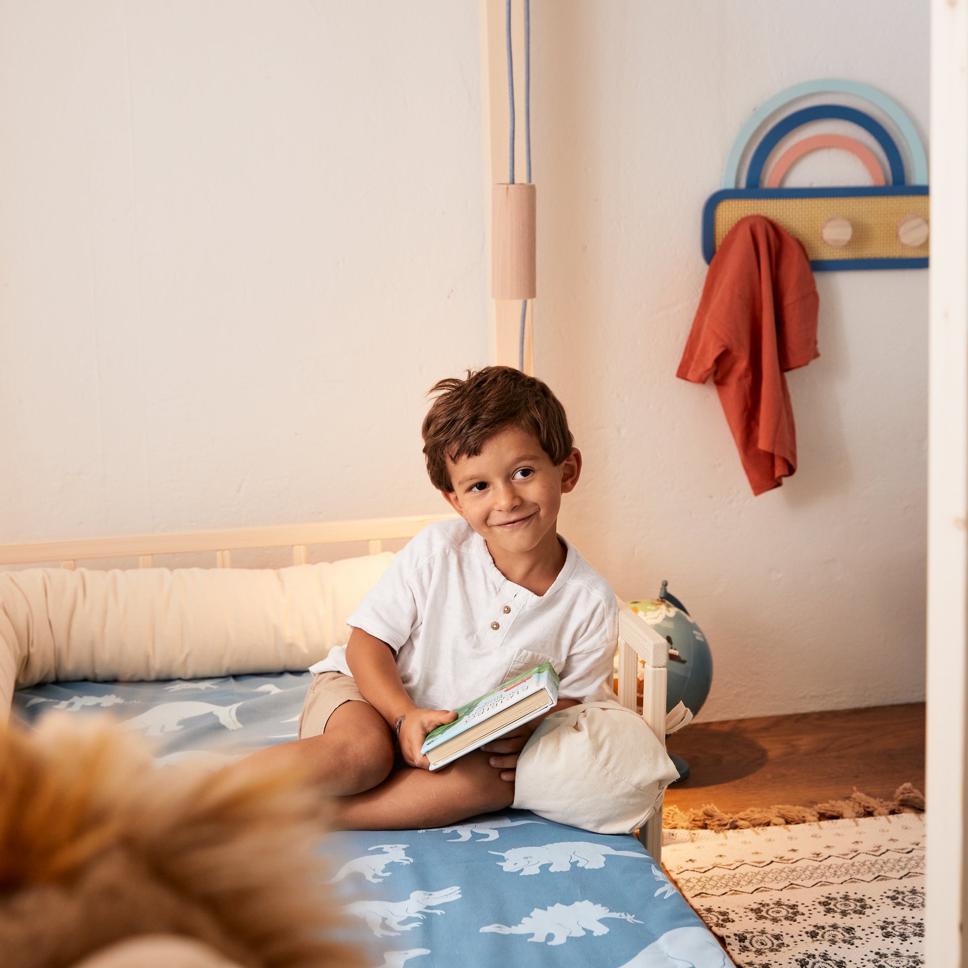 bambino legge su letto montessoriano con materasso evolutivo in schiume ecologiche a base d'acqua senza CFC e senza formaldeide.
